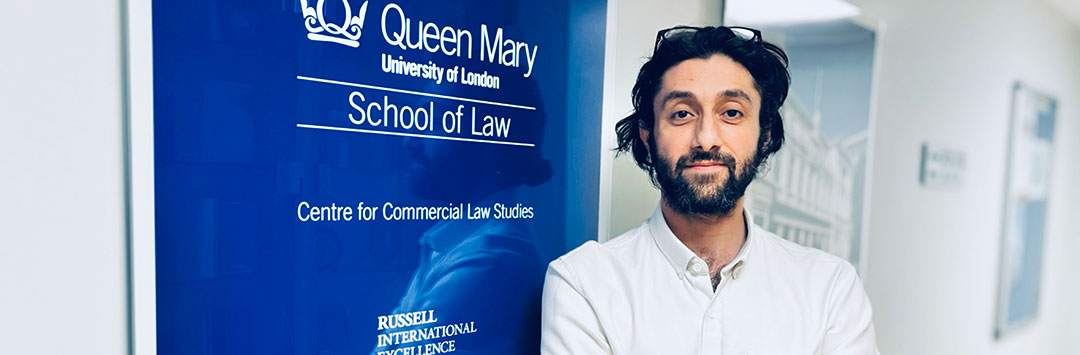 Amir Ghaffari scholarship winner Milad Gazerani in front of a Centre for Commercial Law Studies sign