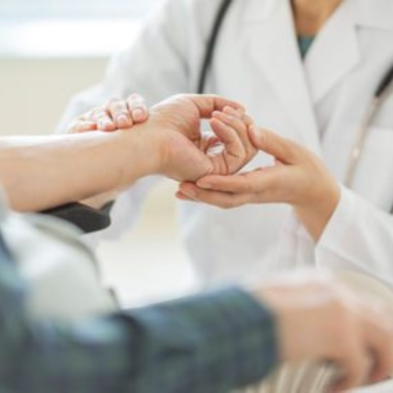 A doctor examining a patient's hand and arm