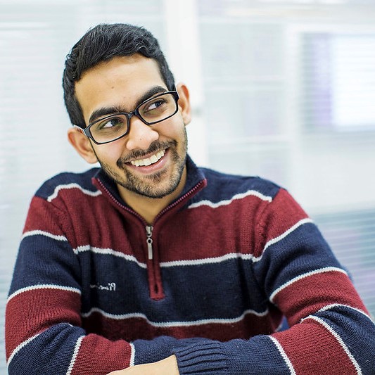 Man sat at a desk and smiling