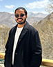 Philip Denny Mathew standing in front of mountains.