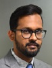 Asian man with beard and glasses in grey suit