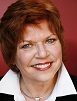 Prof Anne Flanagan in white shirt in front of red background