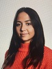 Alumna with long dark hair in orange sweater