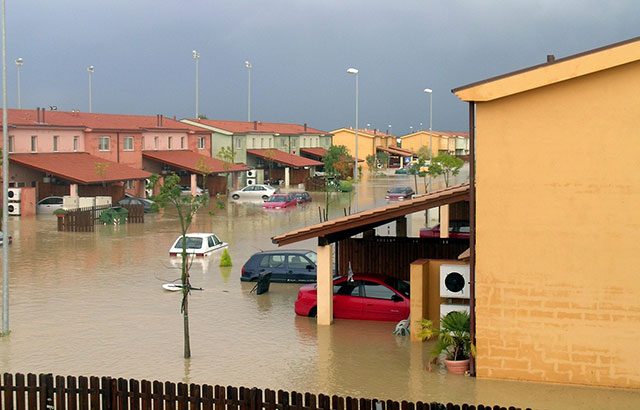 A flooded street of terracotta coloured houses in Sicily.
