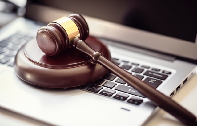 A Justice Gave rests on a laptop