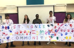 Five Legal Advice Centre Students stand holding a huge colourful banner which reads 
