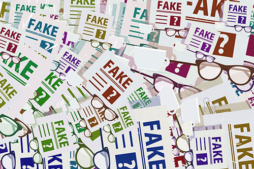 A pile of news paper articles with FAKE written across them