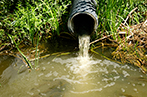 Sewage pipe discharges sewage and wastewater into the river.