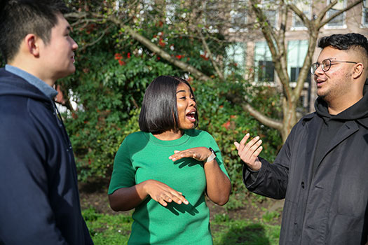 Three Queen Mary postgraduate law students laughing together in Lincolns Inn Fields.