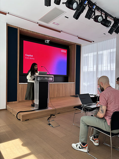 A student standing at a podium in front of a projection screen