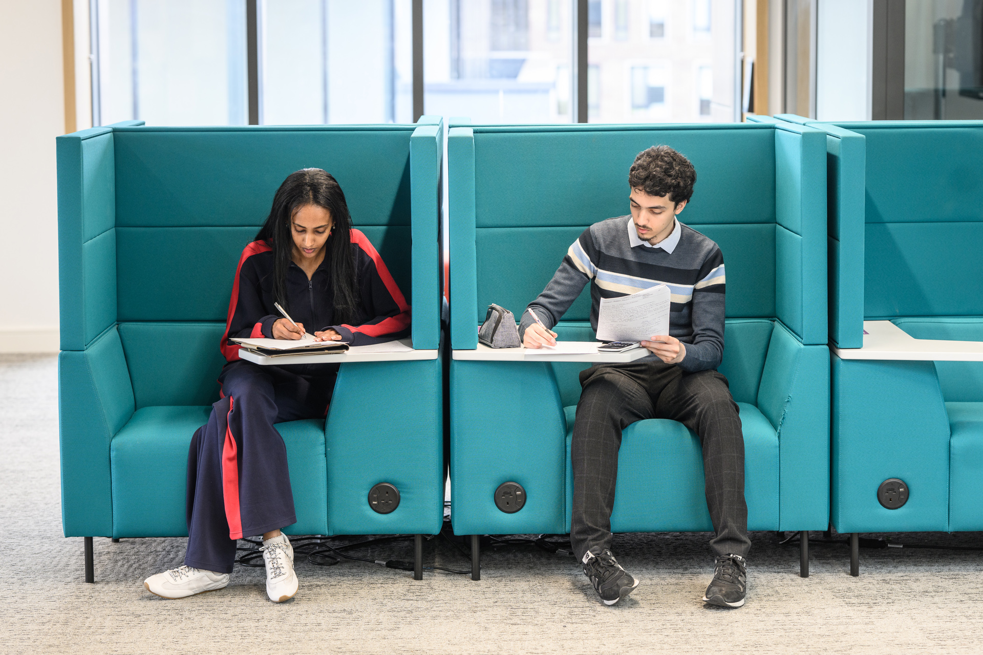 Two students sat on the individual study booths working alone