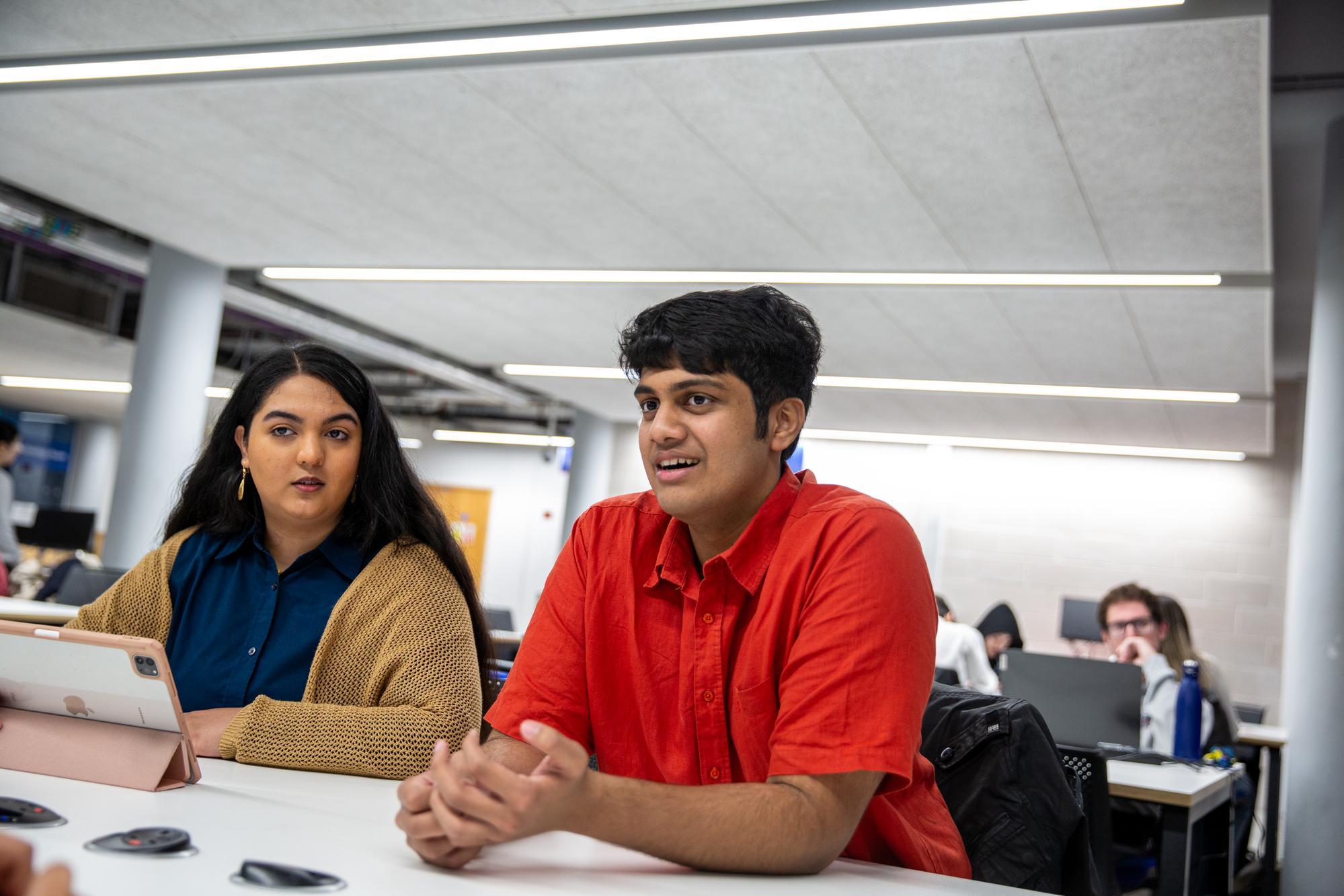 Two students studying together at a group study desk