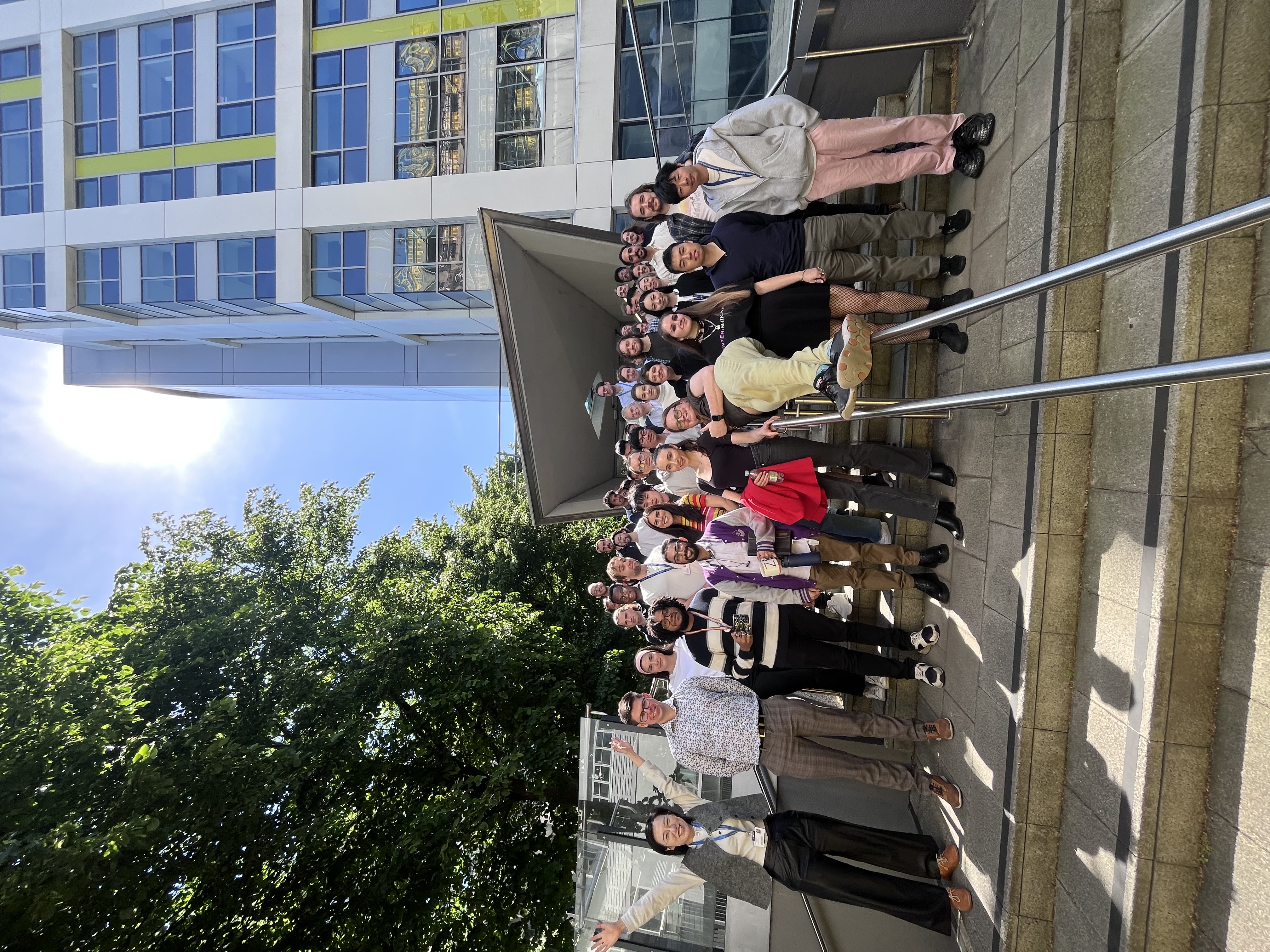 PhD students on the steps of the Maths building, May 2025