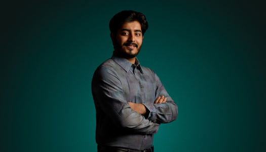 Student Ali Hassan standing against a green background