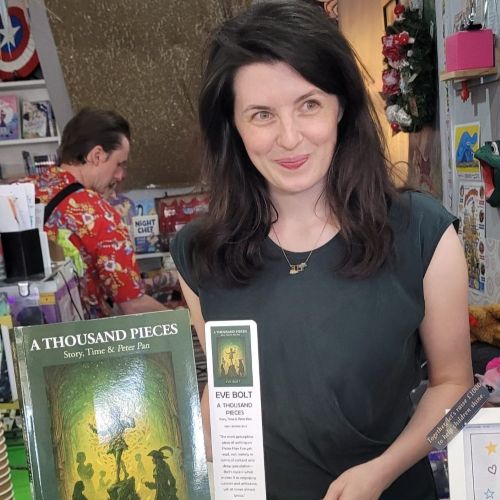 Eve Bolt holding her first published book titled A Thousand Pieces: Story, Time & Peter Pan