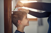 Parent measuring child's height. Credit: iStock.com