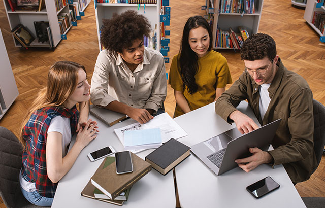 Students at work around a desk with a computer
