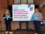 Image of two Queen Mary colleagues, each holding a booklet in their hands and one standing on either side of a TV screen, with a brick wall behind them.