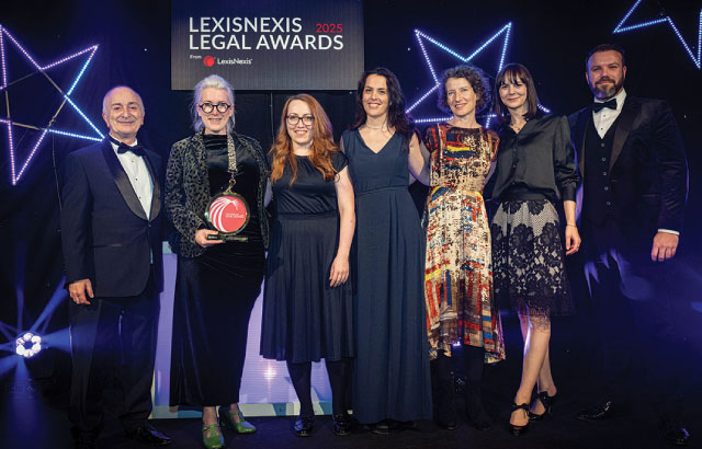 The qLegal team standing with their award, next to Sir Tony Robinson.