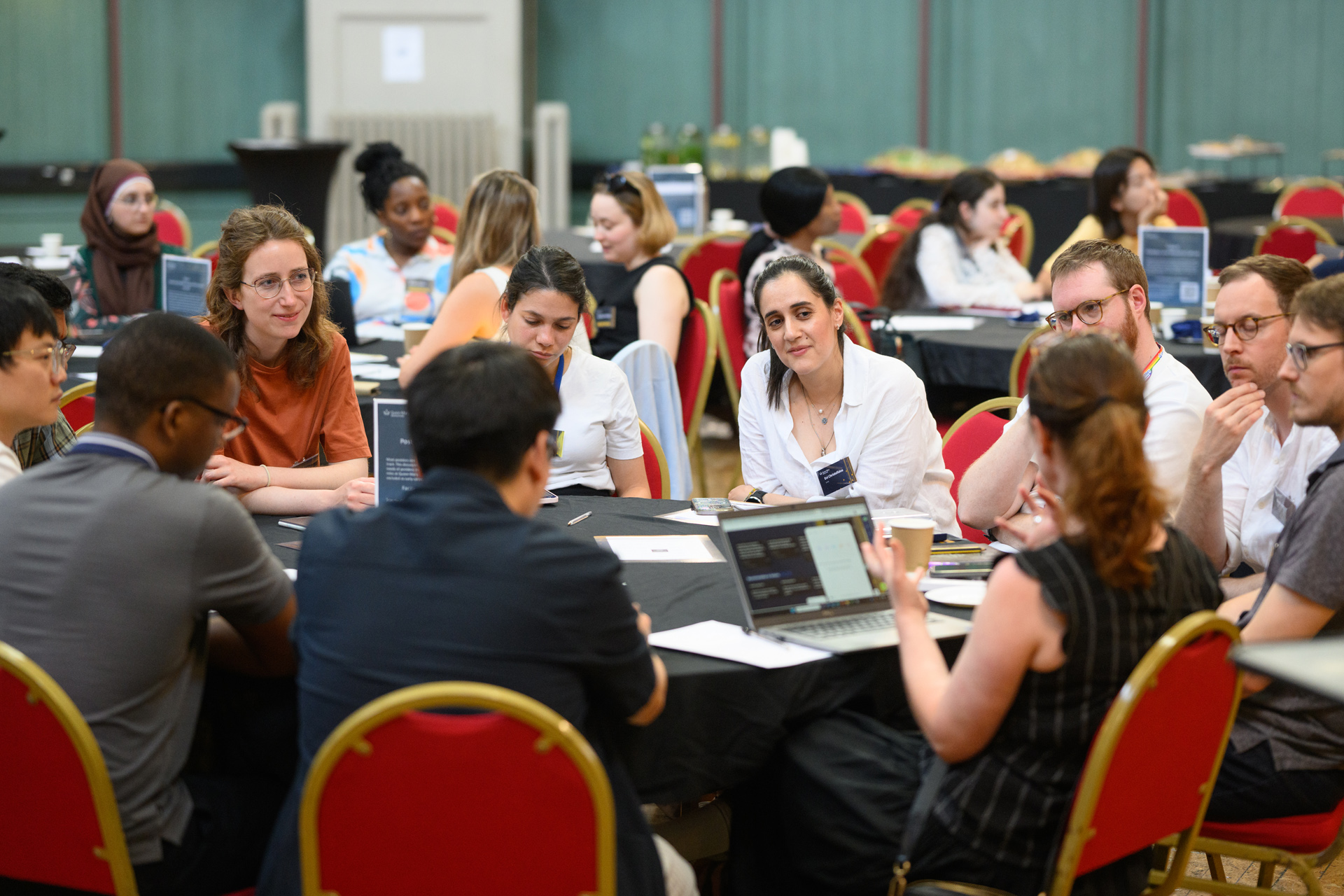 People sat at a table listening to someone at that table speak.